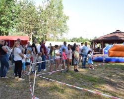 Rodziny z dziećmi w kolejce do dmuchanej zjeżdżalni