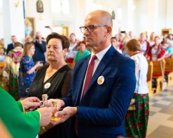 Wójt Gminy przekazuje wino księdzu