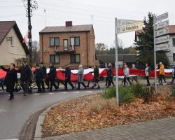 Ludzie niosący flagę ulicami Borowia