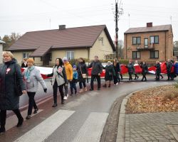 Ludzie niosący flagę ulicami Borowia