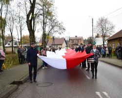 Ludzie niosący flagę RP ulicami Borowia