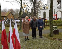 Przedstawiciele zespołów ludowych składają kwiaty
