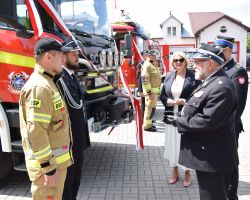 Mężczyźni stojący przy samochodzie strażackim