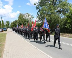 Zdjęcie przedstawia 90-lecie OSP Głosków – 2019 r. – defilada, na czele sztandar OSP Głosków