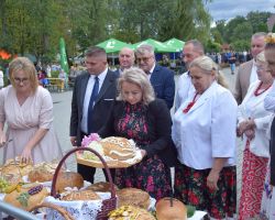 Ludzie stojący przy chlebach dożynkowych