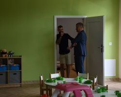 Rozmawia dwóch mężczyzn, wewnątrz budynku