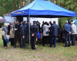 Ludzie pod namiotem, częstują się grochówką