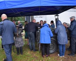 Ludzie pod namiotem, częstują się grochówką