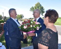 Wójt i Przewodnicząca wręczają kwiaty posłowi Grzegorzowi Woźniakowi