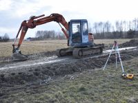 Zdjęcie przedstawia maszyny budowlane podczas prac przy budowie sieci kanalizacji sanitarnej