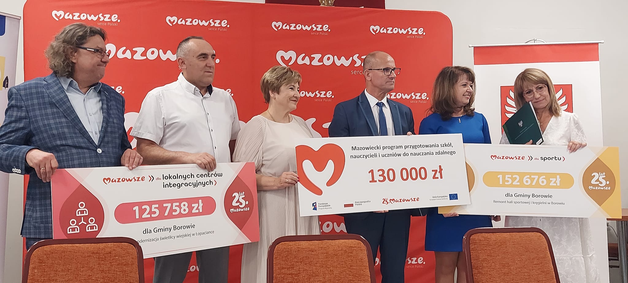 Przedstawiciele samorządu z banerami dot. udzielonych dotacji